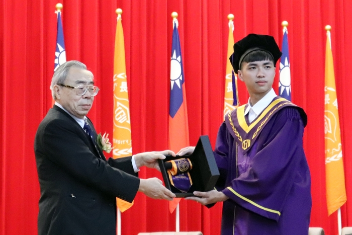 王文淵董事長(圖左)從畢聯會代表林緯群同學(圖右)手中接下具有學校特色及校徽校名綬帶。