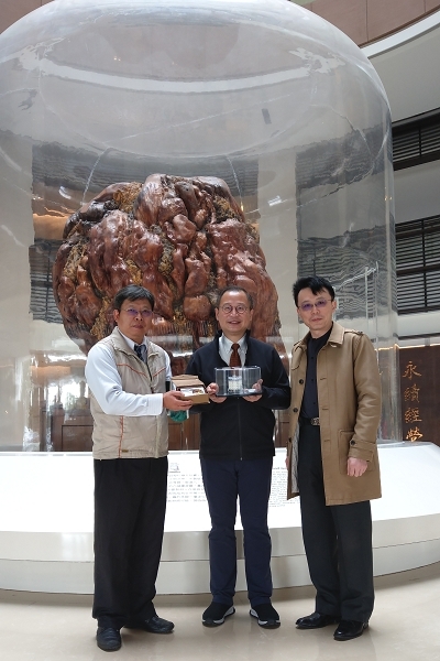 吳前縣長拿著館方贈與的文物館造型積木與學校主管合影
